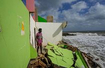 A man stands by the remains of his family's home in Iranawila, Sri Lanka that was destroyed by coastal erosion.