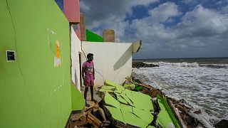 A man stands by the remains of his family's home in Iranawila, Sri Lanka that was destroyed by coastal erosion.