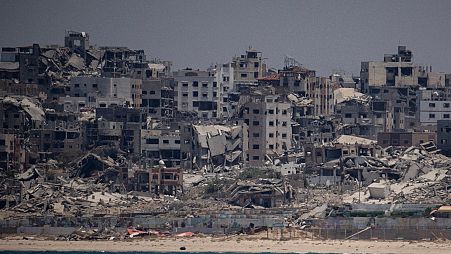 فلسطينيون ينظرون إلى آثار القصف الإسرائيلي على مخيم النصيرات للاجئين بقطاع غزة، في 8 يونيو/حزيران 2024.
