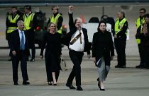 مؤسس ويكيليكس جوليان أسانج يلوح بقبضة يده بعد هبوطه في قاعدة فيربيرن الجوية في كانبيرا، أستراليا. 2024/06/26