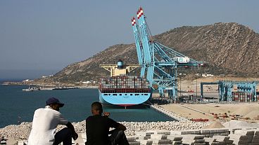 عاملان مغربيان ينظران إلى ميناء طنجة ​​بعد افتتاحه من قبل الملك المغربي محمد السادس في مدينة طنجة الشمالية، الجمعة 27 يوليو 2007