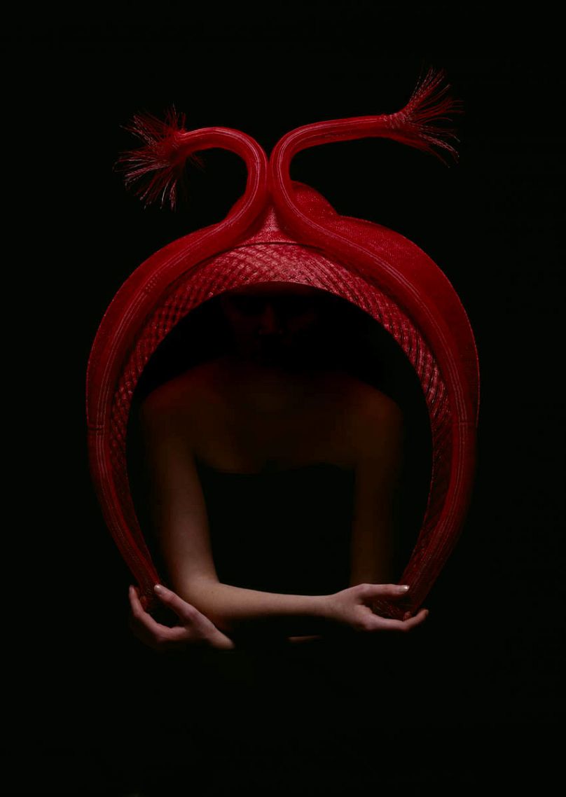 Heart Hat - Legendary milliner Philip Treacy created a sweeping red hat for Primitive Streak. Its horn-like shapes representing the developing heart tubes.