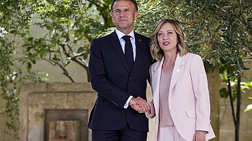 French President Emmanuel Macron, left, is welcomed by Italian Prime Minister Giorgia Meloni during a G7 world leaders summit at Borgo Egnazia in Italy earlier in June