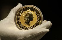 An employee of ProAurum gold house presents the Australian 1 Kg Gold Coin - 999.9 purity in the safe deposit boxes room in Munich, Germany, Thursday, Dec. 13, 2018. (AP Photo/