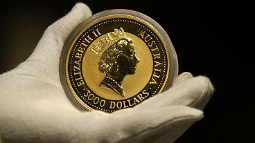 An employee of ProAurum gold house presents the Australian 1 Kg Gold Coin - 999.9 purity in the safe deposit boxes room in Munich, Germany, Thursday, Dec. 13, 2018. (AP Photo/