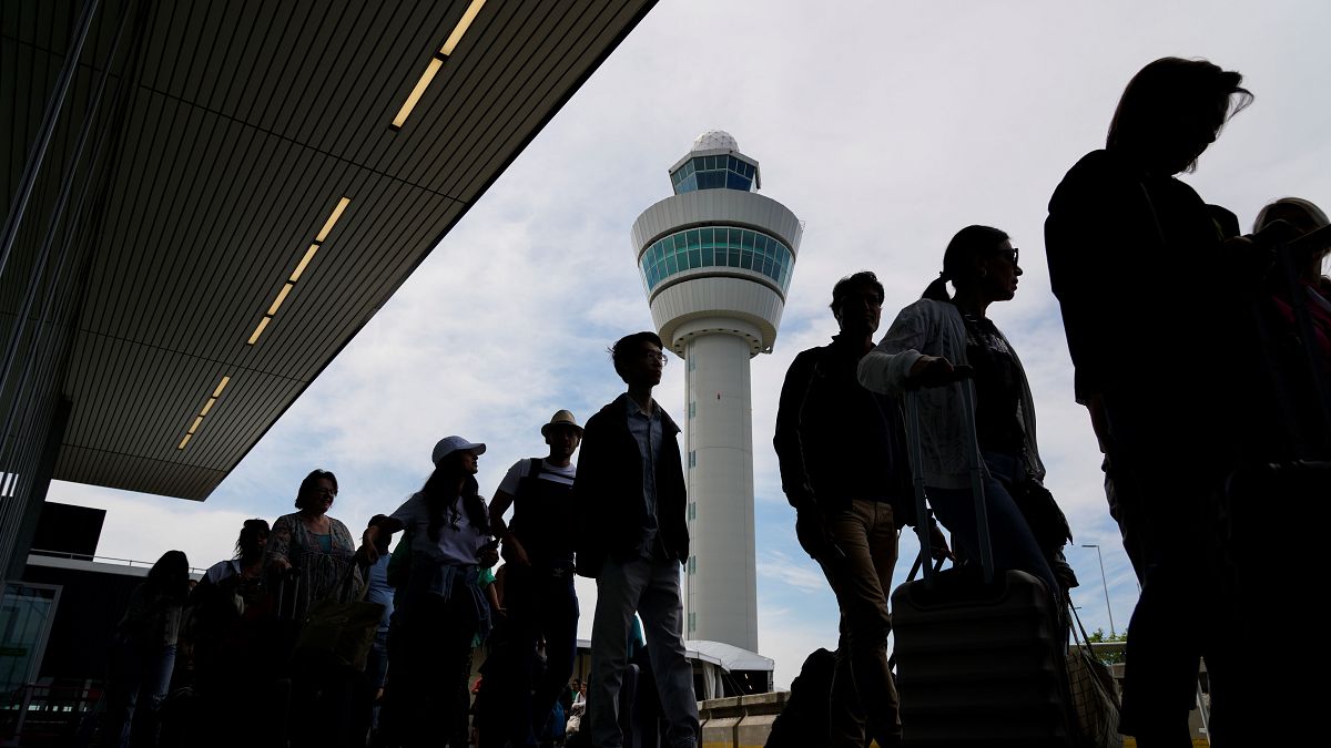 مسافرون في طوابير طويلة خارج مبنى المطار لتسجيل الوصول وركوب الرحلات الجوية في مطار شيفول بأمستردام. 2022/06/21