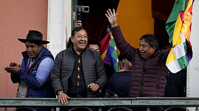 Bolivian President Luis Arce, accompanied by Vice President David Choquehuanca, acknowledge supporters as they stand on a balcony of the government palace..