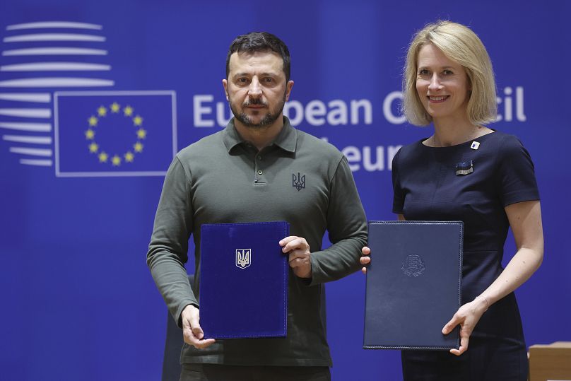 Estonia's Prime Minister poses with Ukraine's President Zelenskyy as they take part in a signature ceremony of a security agreement in Brussels.