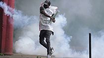 A protester returns back a teargas canister to Kenya police in Nairobi, Kenya Thursday, June 27, 2024.