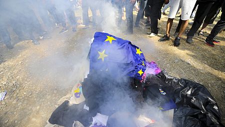 Opositores georgianos a los derechos de los homosexuales queman banderas LGBT y de la UE mientras intentan interferir en el orgullo en Tbilisi, Georgia, el 8 de julio de 2023.