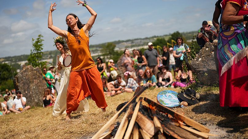 Menschen tanzen auf dem Steinkreis während des Glastonbury-Festivals