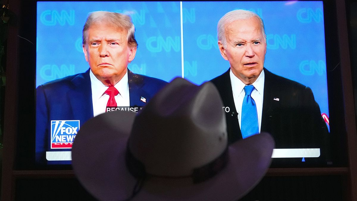 A man wears a cowboy hat as he watches the presidential debate between Joe Biden and Donald Trump in Scottsdale, AZ, 27 June 2024