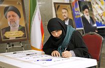 Bir kadın, 28 Haziran 2024 Cuma günü Irak'ın başkenti Bağdat'taki İran Büyükelçiliği'nin içindeki bir sandıkta cumhurbaşkanlığı seçimleri sırasında oyunu kullanıyor. 