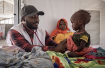 Оказание гуманитарной помощи в Судане: врач прослушивает девочку.