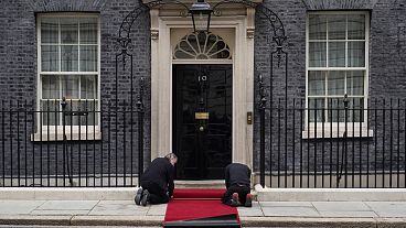 Des ouvriers mettent en place le tapis rouge sur le pas de la porte du 10 Downing Street. Mardi 9 avril 2024.