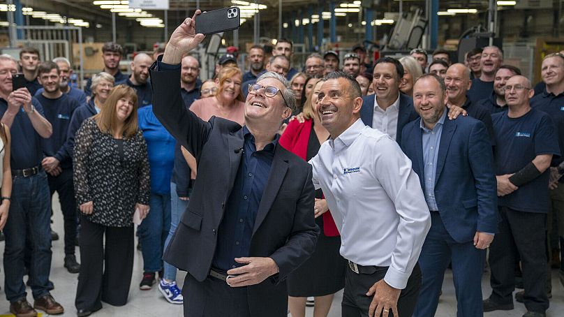 Labour Party leader Sir Keir Starmer takes a selfie alongside staff during a visit to Window Supply Company in Bathgate, West Lothian, Friday June 21, 2024.