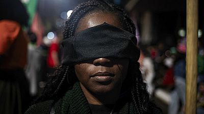 An abortion rights activist with a band over her eyes protests an anti-abortion bill in Congress