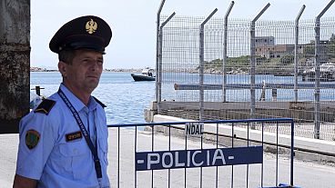 Un policía vigila en un centro de acogida para migrantes, en el puerto de Shëngjin, en el noroeste de Albania, el miércoles 5 de junio de 2024.