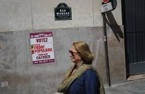 امرأة تمشي أمام ملصق مكتوب عليه «صوّت للجبهة الشعبية الجديدة» قبل الانتخابات البرلمانية المقبلة - باريس.