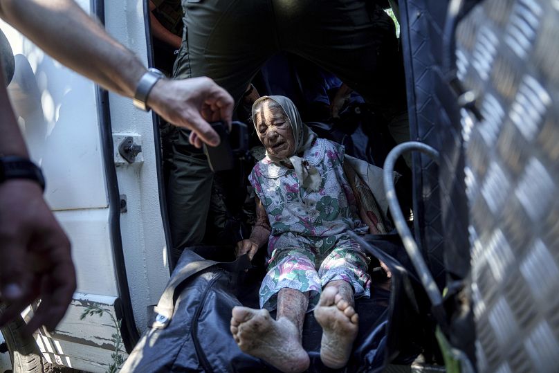 Uma mulher idosa com deficiência senta-se dentro de uma carrinha durante a evacuação para zonas seguras em Toretsk, 28 de junho de 2024