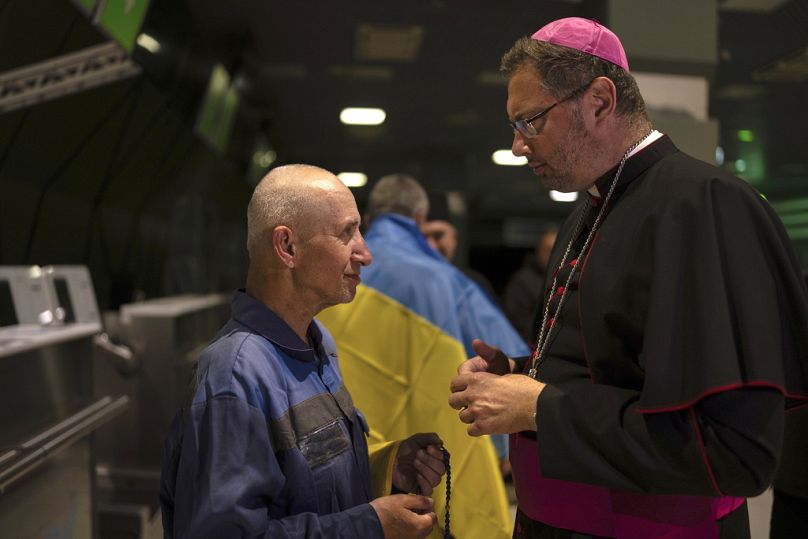 Priest Bohdan Heleta, left, who was detained inside his own church in the occupied city of Berdiansk in the Zaporizhzhia region in 2022, speaks to his friend in Kyiv airport,