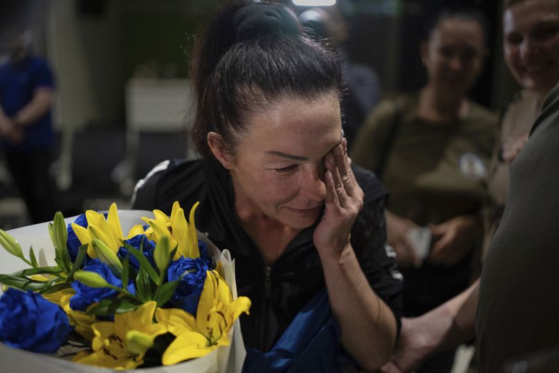 Olena Pekh, investigadora del Museo de Arte de Horlivka, llora mientras habla con su hija por videoseñal en el aeropuerto de Kiev, Ucrania, el sábado 29 de junio de 2024.