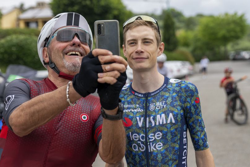 Un feliz aficionado al ciclismo se toma un selfie con el danés Jonas Vingegaard en Florencia, Italia, 23 de junio de 2024.