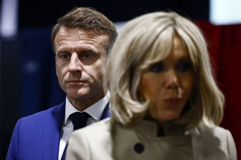 French President Emmanuel Macron and his wife Brigitte Macron stand in the voting station before voting in Le Touquet-Paris-Plage, northern France, Sunday, June 30, 2024.