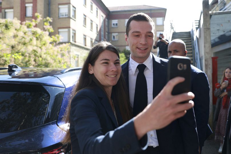 Jordan Bardella posa para uma selfie depois de votar no domingo.