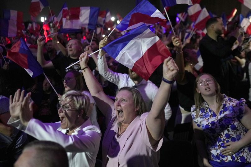 Supporters of French far right leader Marine Le Pen react after the release of projections based on the actual vote count in select constituencies , Sunday, June 30, 2024 in H
