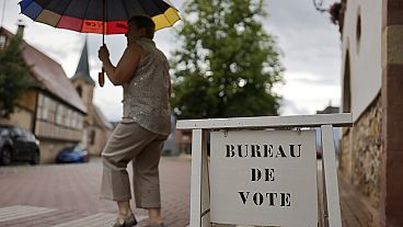 Um eleitor sai da mesa de voto em Wolxheim, no leste de França, na eleições legislativas 2024.
