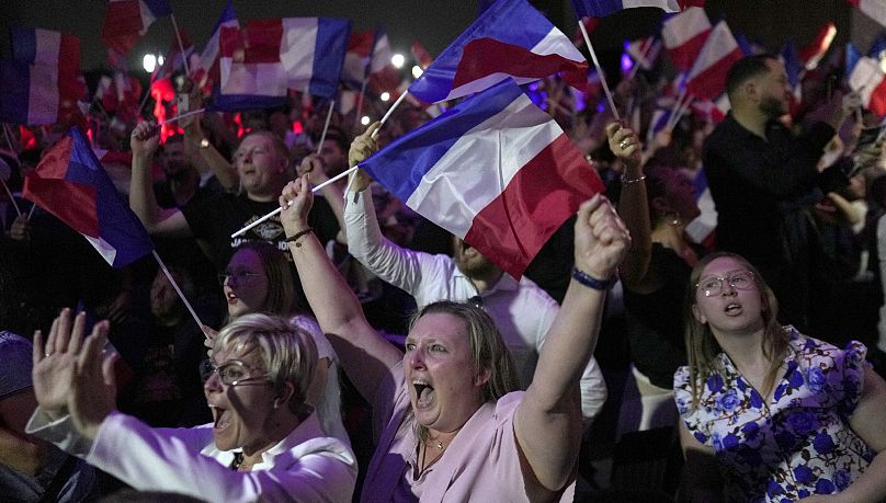 I sostenitori della leader dell'estrema destra francese Marine Le Pen reagiscono dopo la pubblicazione delle proiezioni delle elezioni legislative a Henin-Beaumont