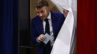 O Presidente francês Emmanuel Macron sai da cabina de voto antes de votar em Le Touquet-Paris-Plage, no norte de França, no domingo, 30 de junho de 2024.