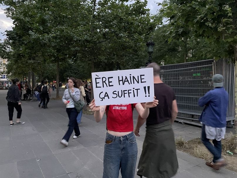 Un manifestant avec une pancarte anti-RN.