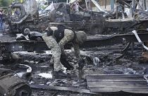 Egy rendőr bizonyítékokat gyűjt a Nova Poshta raktár ellen elkövetett orosz támadás után Harkivban, 2024. június 30.