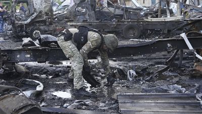 A police officer collects evidence after a Russian attack on a Nova Poshta depot in Kharkiv, June 30, 2024