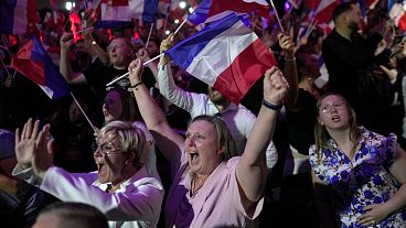 Os apoiantes da líder da extrema-direita francesa, Marine Le Pen, reagem após a divulgação das projecções baseadas na contagem dos votos reais.