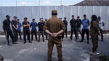 Prisoners listen to a Ukrainian sergeant of the Battalion Arey during an interview in a prison.