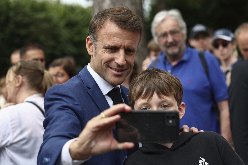 French President Emmanuel Macron takes a selfie with a boy after voting in Le Touquet-Paris-Plage, northern France, Sunday, June 30, 2024. 