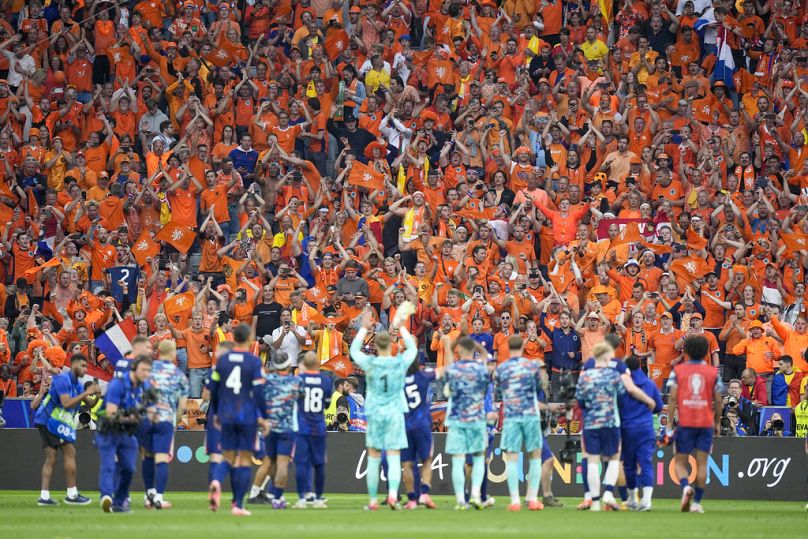 Netherlands fans and players celebrate their victory during a round of sixteen match between Romania and the Netherlands at Euro 2024 