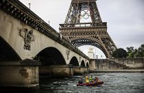 Un barco navega por el río Sena cerca de la Torre Eiffel durante un ensayo para la ceremonia de los Juegos Olímpicos de París 2024, junio de 2024 en París.