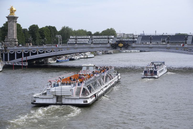 Des touristes sur un bateau mouche sur la Seine à Paris en juin 2024