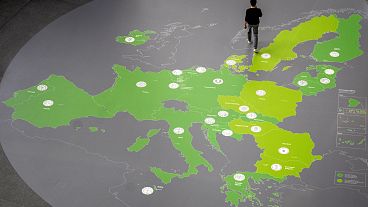 Almanya'nın Frankfurt kentindeki Avrupa Merkez Bankası koridorunda bir adam Avro Bölgesi ülkelerini gösteren bir harita üzerinde yürüyor