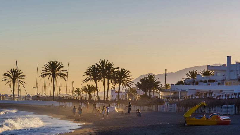 Urlauber tummeln sich an einem Strand in Marbella, Spanien.