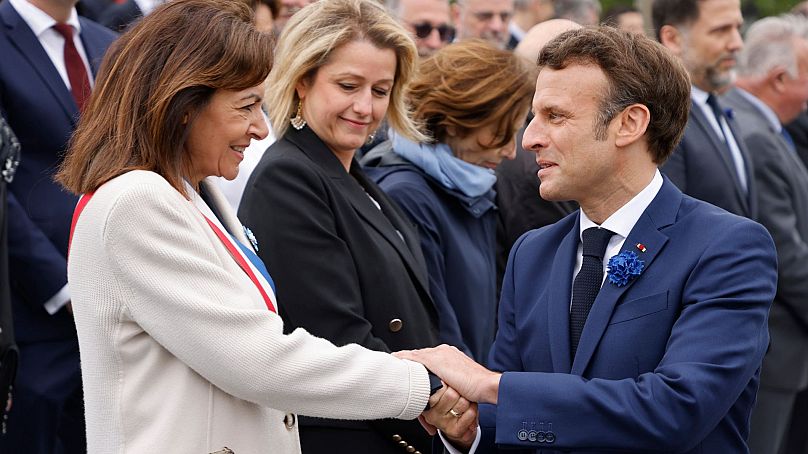 Paris Belediye Başkanı Anne Hidalgo, Fransa Cumhurbaşkanı Emmanuel Macron ile el sıkışıyor.