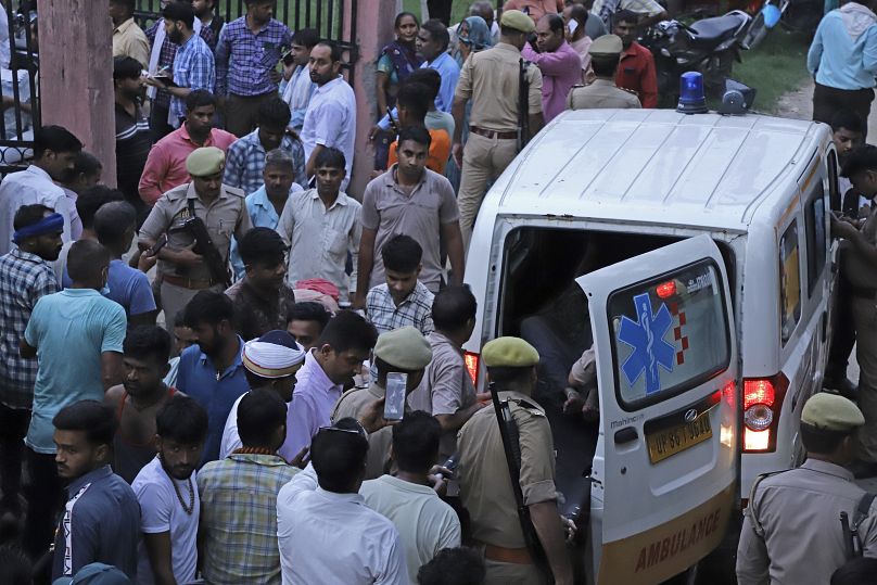 حشد من الهنود حول سيارة إسعاف تنقل مصابي حادث التدافع