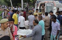 Des proches et des bénévoles transportent les corps sur des brancards à l'hôpital Sikandrarao, dans le district de Hathras.