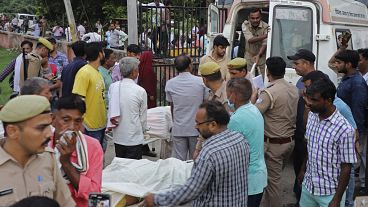 Parenti e volontari trasportano i corpi verso l'ospedale Sikandrarao nel distretto di Hathras, in India