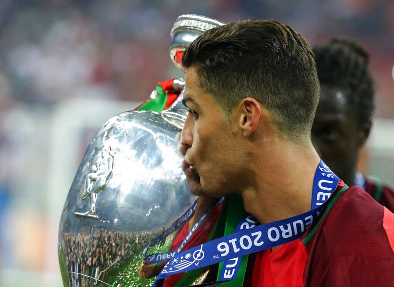 Portugal's Cristiano Ronaldo kisses the trophy after winning the Euro 2016 final soccer match between Portugal and France at the Stade de France in Saint-Denis, 10/07/2016