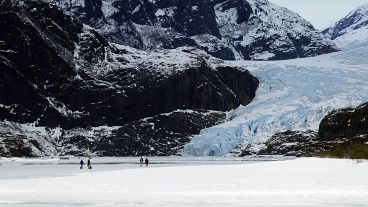 سياح يتجولون فوق بحيرة مندنهال المتجمدة في جونو بألاسكا الأمريكية بتاريخ: 18 فبراير/شباط 2024